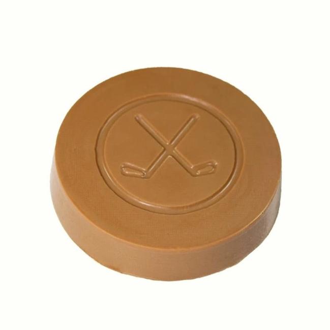 A solid chocolate hockey puck with a design of hockey sticks on it, presented on a white background.