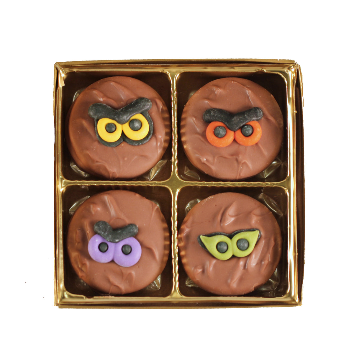 A box of chocolate covered Oreo cookies with Halloween themed decorations on top, displayed in a clear packaging.
