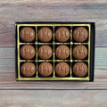 A box of chocolate maple butter creams with a golden interior.