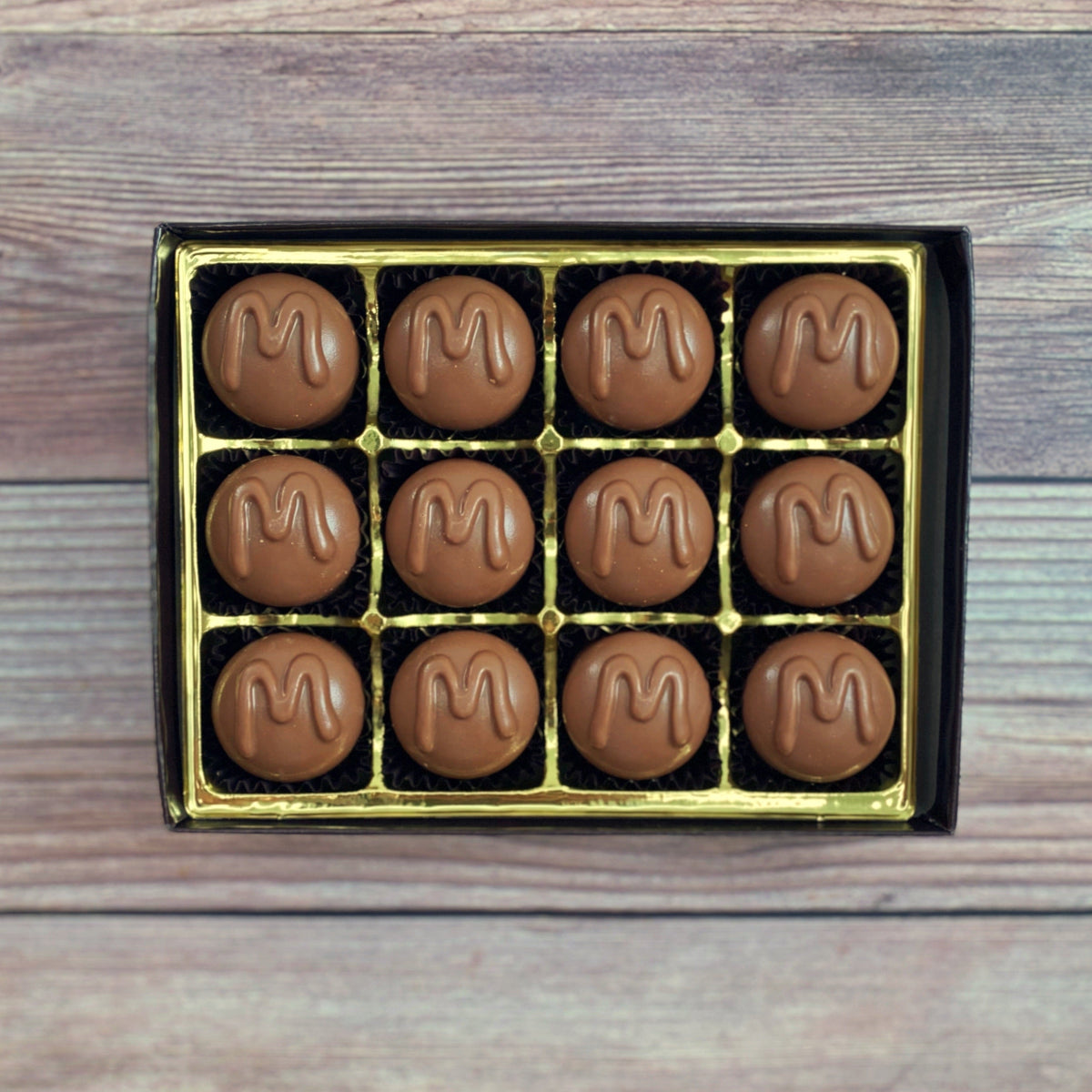 A box of chocolate maple butter creams with a golden interior.