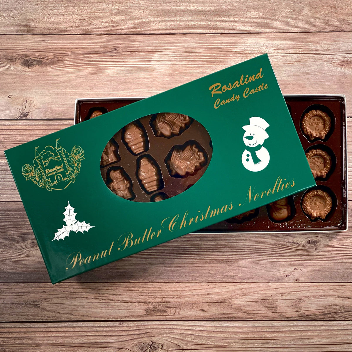 A box of peanut butter filled milk chocolate novelties, presented in a Christmas-themed packaging with snowman and holly designs.
